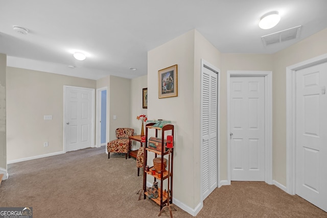 hallway featuring carpet flooring, baseboards, and visible vents
