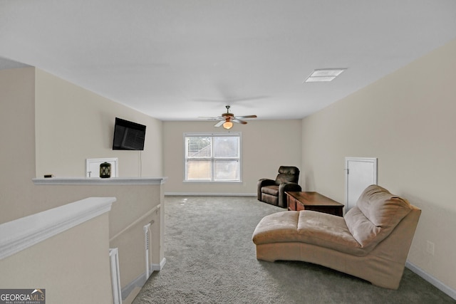 living area with light colored carpet, baseboards, and a ceiling fan