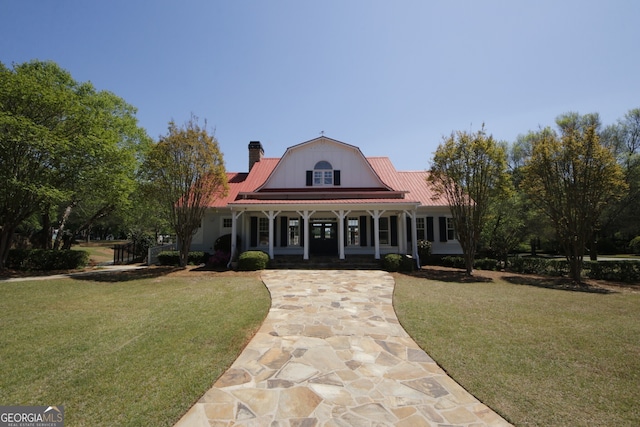 view of front of home with a porch, a gambrel roof, metal roof, and a front yard