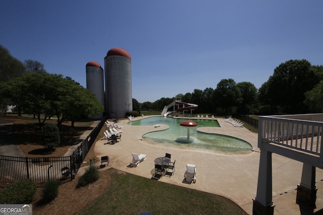 view of community featuring fence and a patio