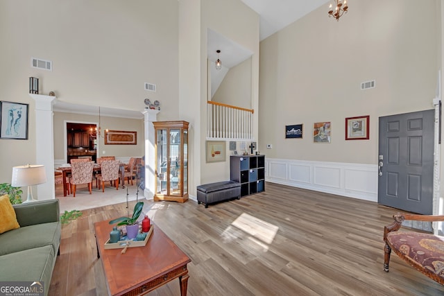 living area with visible vents, high vaulted ceiling, and a notable chandelier