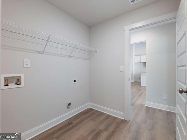 laundry area featuring baseboards, electric dryer hookup, laundry area, hookup for a washing machine, and wood finished floors