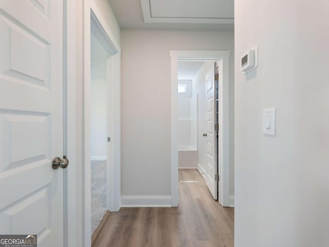 hall featuring wood finished floors and baseboards