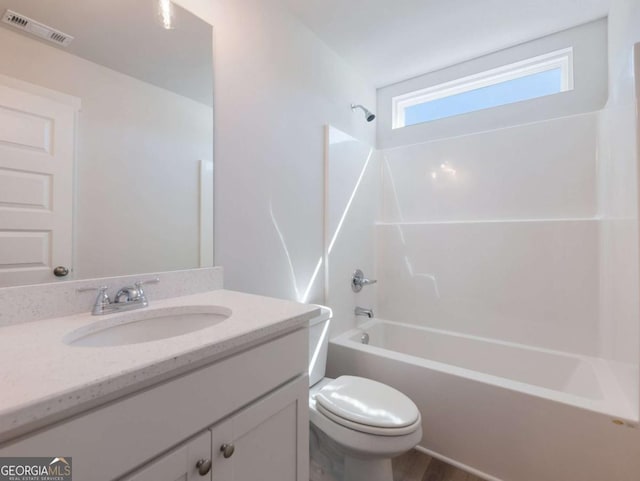 bathroom with toilet, vanity, shower / tub combination, and visible vents