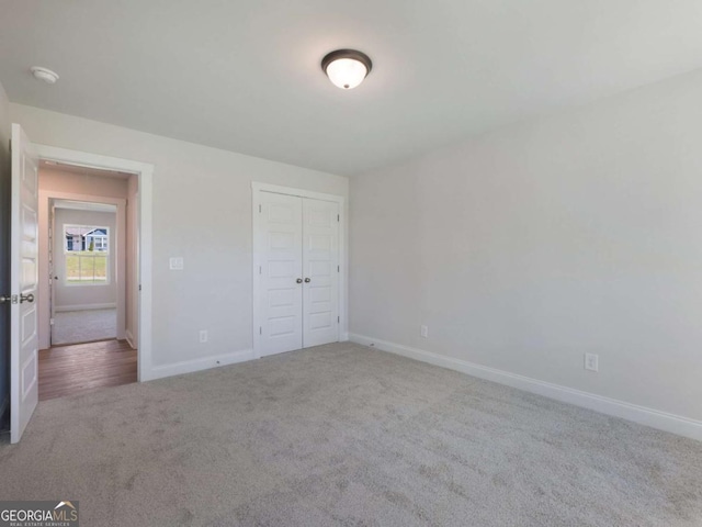 unfurnished bedroom featuring a closet, baseboards, and carpet
