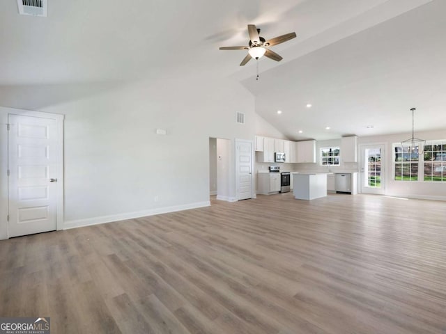 unfurnished living room with visible vents, baseboards, and a ceiling fan