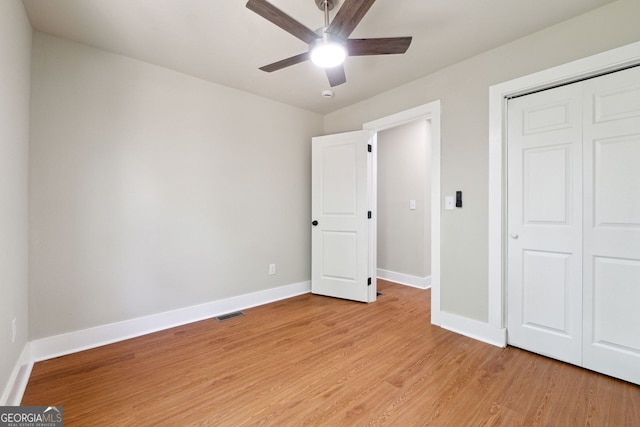 unfurnished bedroom featuring a closet, baseboards, visible vents, a ceiling fan, and light wood finished floors
