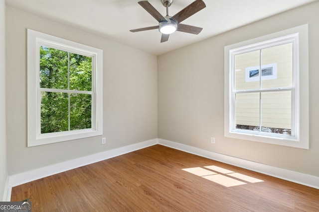empty room with wood finished floors, ceiling fan, and baseboards