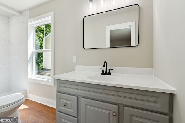 full bathroom with vanity, baseboards, toilet, a shower, and wood finished floors