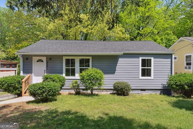 view of front of home with a shingled roof and a front lawn