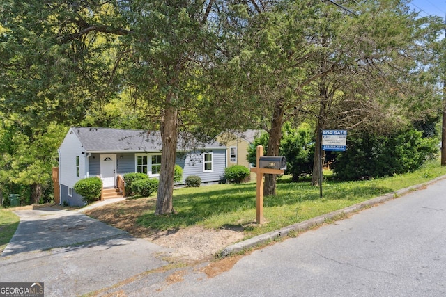 view of front of home with concrete driveway and a front yard