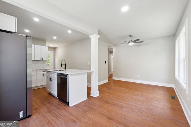 kitchen featuring appliances with stainless steel finishes, light countertops, white cabinetry, ceiling fan, and a sink