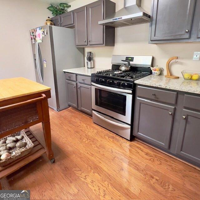 33 Mountain View Dr, Rockmart, GA 30153 - kitchen with wall chimney exhaust hood, stainless steel gas stove, fridge with ice dispenser, and gray cabinetry