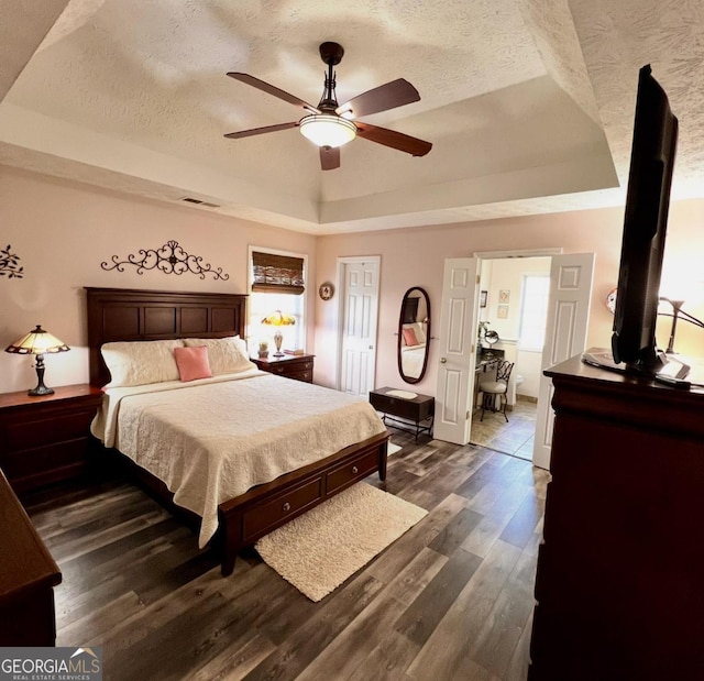 33 Mountain View Dr, Rockmart, GA 30153 - bedroom with a tray ceiling, a textured ceiling, dark wood-type flooring, and a ceiling fan