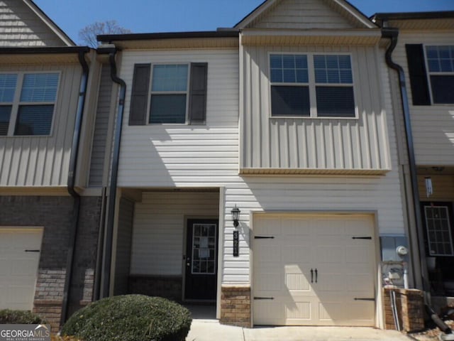 multi unit property featuring board and batten siding, stone siding, and an attached garage