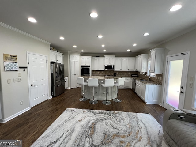 kitchen with decorative backsplash, crown molding, a breakfast bar area, and stainless steel appliances