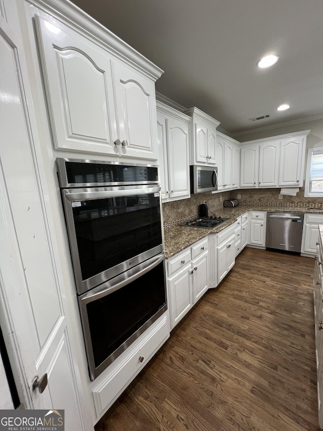 kitchen featuring white cabinets, dark stone counters, visible vents, and appliances with stainless steel finishes
