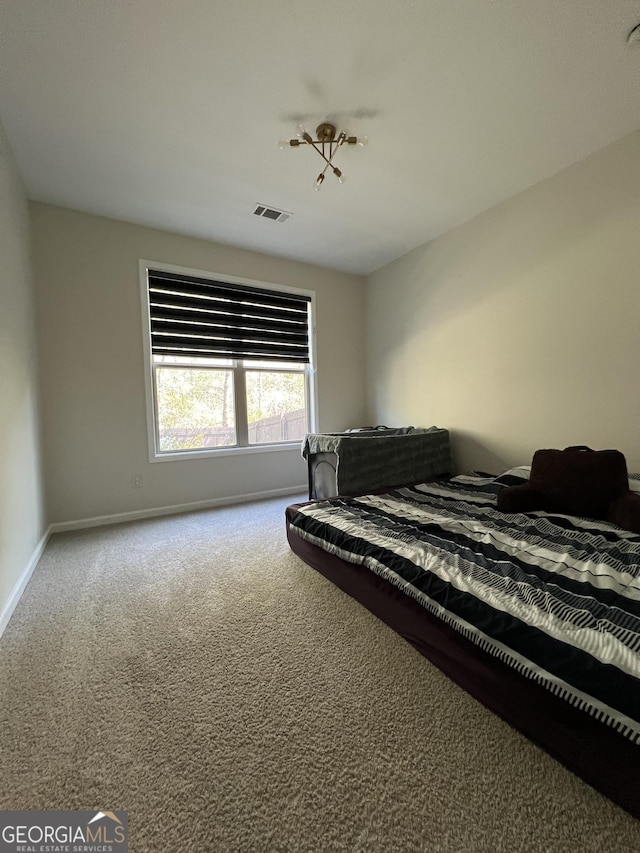 bedroom with baseboards, visible vents, and carpet