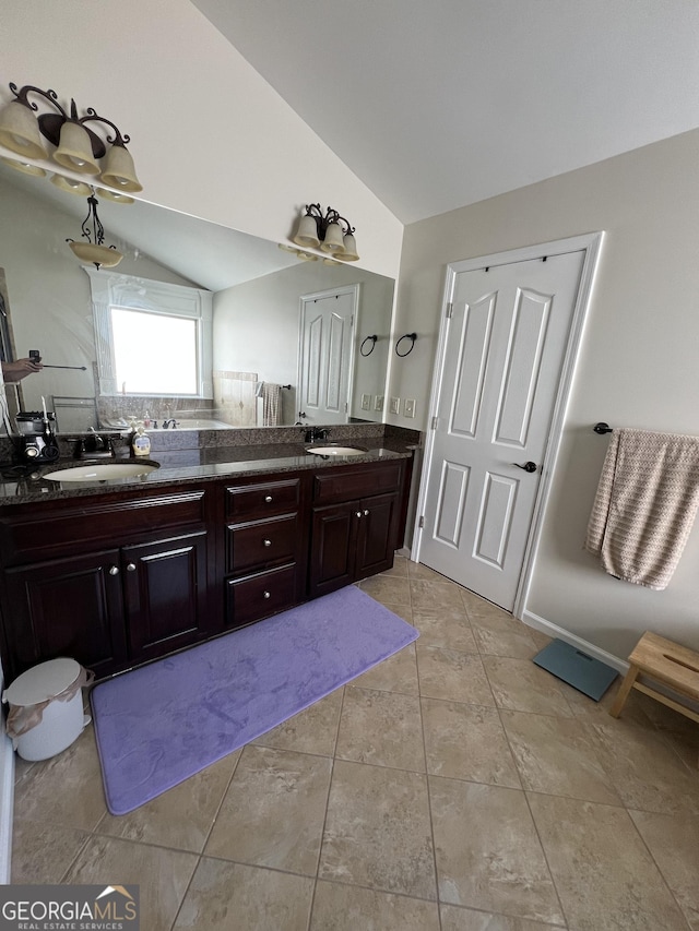 full bath featuring lofted ceiling, tile patterned floors, a sink, and double vanity