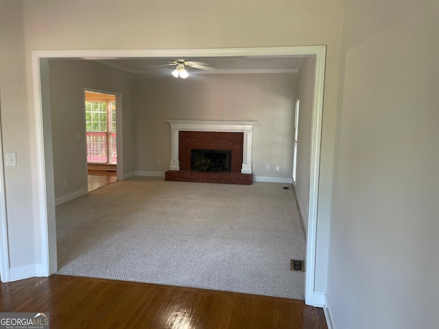 8100 Greens Mill Way, Loganville, GA 30052 - unfurnished living room featuring ceiling fan, a brick fireplace, carpet floors, baseboards, and ornamental molding