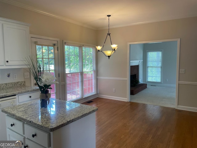 8100 Greens Mill Way, Loganville, GA 30052 - kitchen featuring healthy amount of natural light, wood finished floors, baseboards, white cabinetry, and ornamental molding