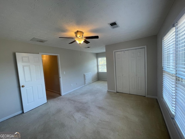8100 Greens Mill Way, Loganville, GA 30052 - unfurnished bedroom with carpet floors, baseboards, a closet, a ceiling fan, and a textured ceiling
