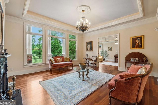 6935 Wakehurst Pl, Cumming, GA 30040 - living area with a tray ceiling, a chandelier, ornamental molding, wood finished floors, and baseboards