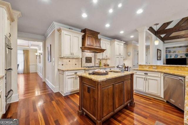 6935 Wakehurst Pl, Cumming, GA 30040 - kitchen with stainless steel appliances, custom exhaust hood, ornamental molding, a sink, and dark wood-style floors