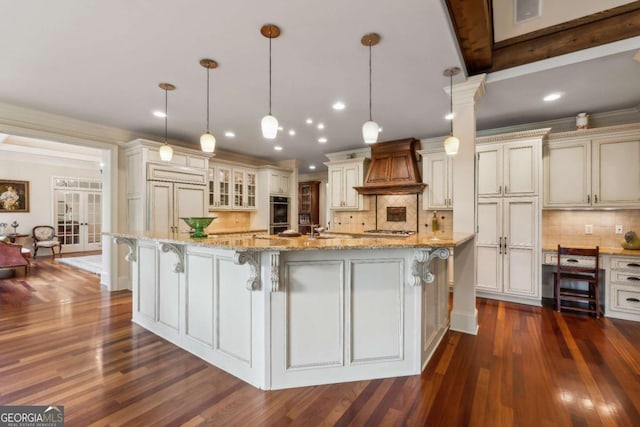 6935 Wakehurst Pl, Cumming, GA 30040 - kitchen featuring custom exhaust hood, tasteful backsplash, dark wood-type flooring, a breakfast bar, and recessed lighting