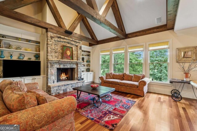6935 Wakehurst Pl, Cumming, GA 30040 - living area featuring high vaulted ceiling, wood finished floors, a fireplace, beamed ceiling, and built in features