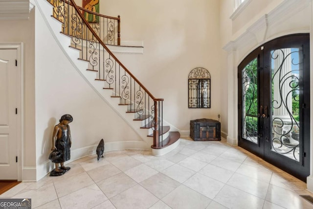 6935 Wakehurst Pl, Cumming, GA 30040 - foyer entrance with healthy amount of natural light, stairway, tile patterned floors, baseboards, and a high ceiling