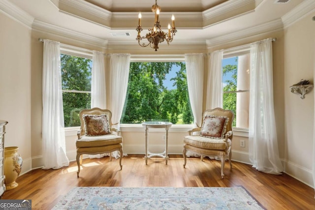 6935 Wakehurst Pl, Cumming, GA 30040 - living area featuring plenty of natural light, a chandelier, ornamental molding, and wood finished floors