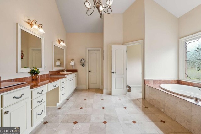 6935 Wakehurst Pl, Cumming, GA 30040 - full bath featuring a garden tub, vanity, a chandelier, high vaulted ceiling, and tile patterned floors