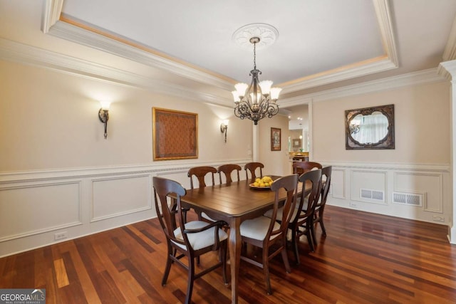 6935 Wakehurst Pl, Cumming, GA 30040 - dining room featuring a tray ceiling, crown molding, a chandelier, dark wood finished floors, and a wainscoted wall