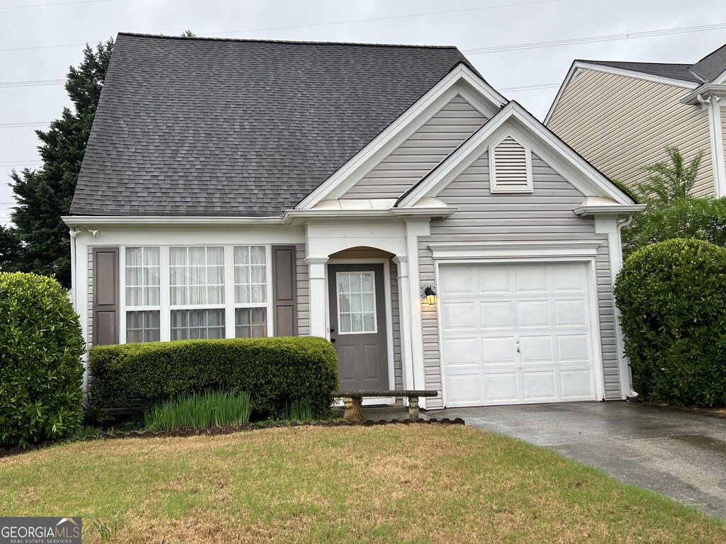 1668 Woodsford Rd, Kennesaw, GA 30152 - view of front of house featuring a garage, aphalt driveway, roof with shingles, and a front lawn