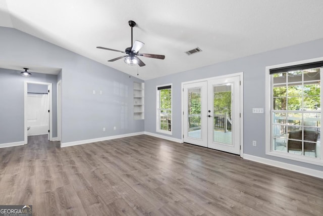 348 Bluegill Rd, Eatonton, GA 31024 - unfurnished living room with french doors, wood finished floors, vaulted ceiling, ceiling fan, and built in shelves