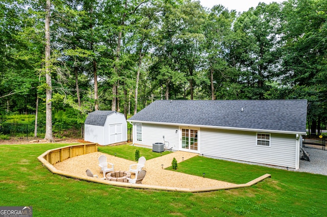 348 Bluegill Rd, Eatonton, GA 31024 - rear view of property featuring an outdoor fire pit, a shingled roof, a storage unit, and a patio