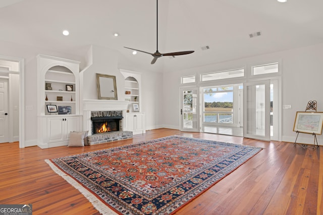 2091 Juliention Dr NE, Townsend, GA 31331 - living room featuring built in shelves, baseboards, a brick fireplace, ceiling fan, and hardwood / wood-style flooring