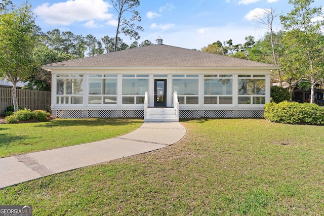 2091 Juliention Dr NE, Townsend, GA 31331 - view of front of home with a front lawn, fence, a sunroom, and roof with shingles
