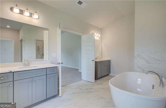 140 Cooper Cv E Lot 21, Fayetteville, GA 30215 - bathroom with two vanities, marble look tile flooring, a freestanding tub, and a walk in closet