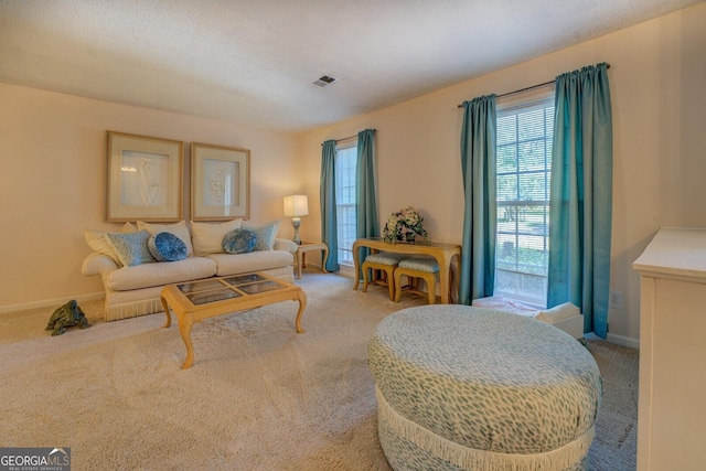living room with light carpet, visible vents, and baseboards