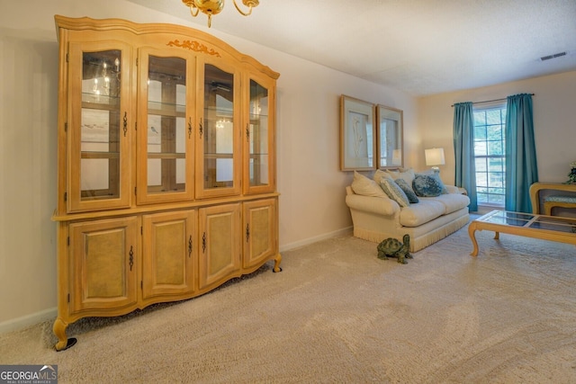 living area with visible vents, baseboards, and carpet