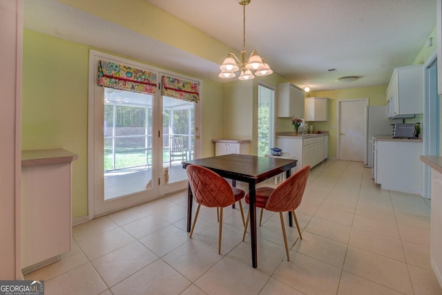 dining space featuring light tile patterned flooring and a notable chandelier