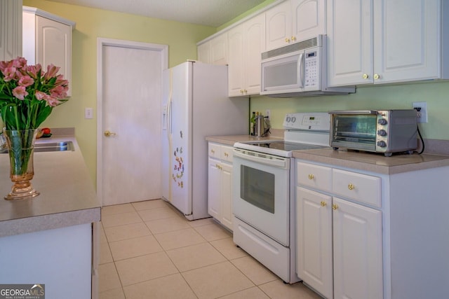 kitchen featuring white appliances, white cabinetry, light tile patterned flooring, light countertops, and a toaster