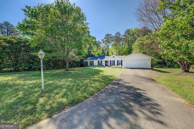 ranch-style home with a garage, driveway, and a front lawn