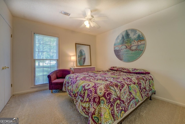 bedroom featuring baseboards, a ceiling fan, visible vents, and carpet floors