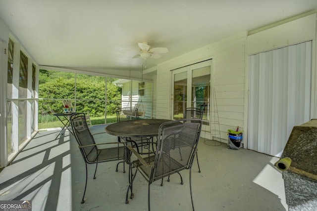 sunroom featuring outdoor dining space, a wealth of natural light, and ceiling fan