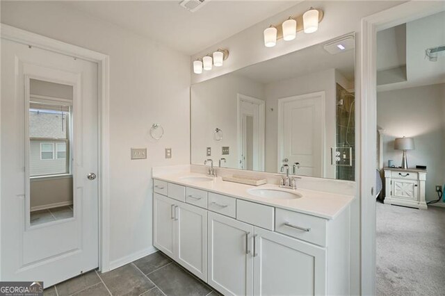 full bathroom with double vanity, visible vents, baseboards, and a sink
