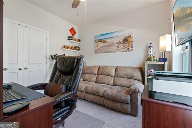 carpeted office space with a ceiling fan