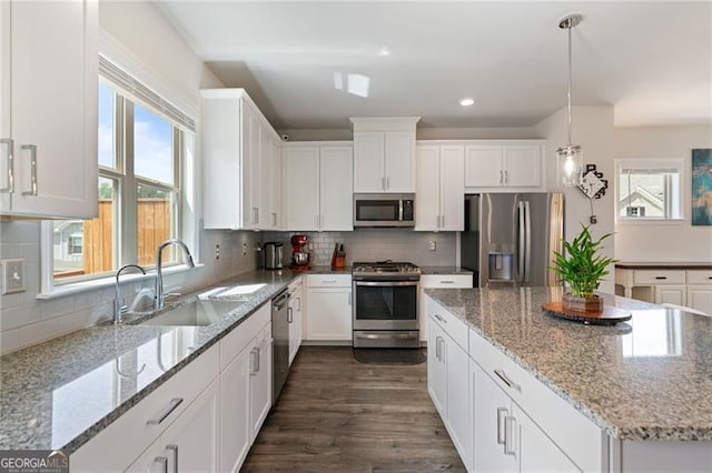 kitchen featuring a sink, dark wood-style floors, white cabinetry, stainless steel appliances, and decorative backsplash